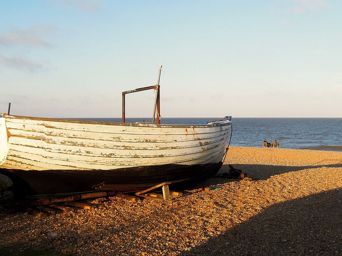 An old wooden fishing boat on the shingle beach at Dunwich, Suffolk